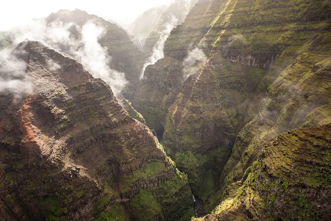 Looking down on green valleys and waterfalls from a helicopter